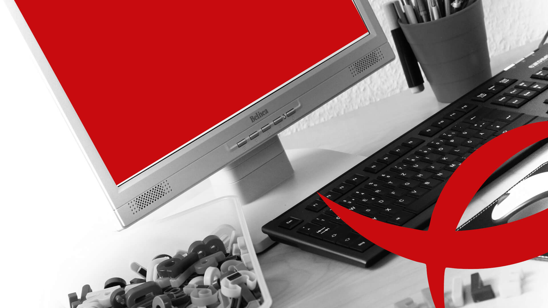 Geriatrie Schreibtisch mit Monitor, Tastatur, Stiftehalter und Lernmaterial.