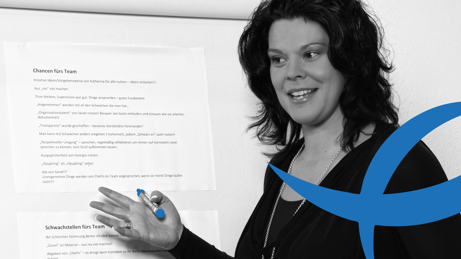Gruppenkurse Frau Tribl präsentiert Teamideen auf einem Whiteboard, hält blauen Marker in der Hand.